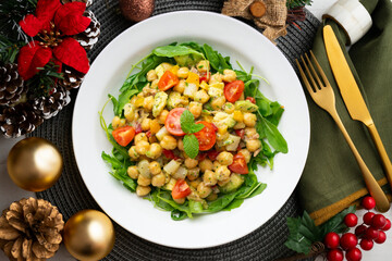 Mediterranean chickpea salad with avocados and vegetables. Top view table with christmas decorations.