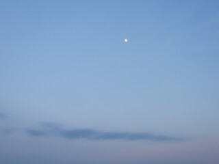 Daytime moon, visible in blue sky, above the Bombay hook National Wildlife Refuge, Kent County, Delaware.