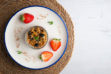 Greek yogurt with strawberries and granola made with cereals and nuts. Top view table with christmas decorations.