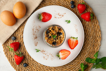 Greek yogurt with strawberries and granola made with cereals and nuts. Top view table with christmas decorations.
