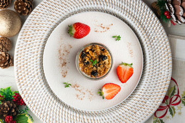 Greek yogurt with strawberries and granola made with cereals and nuts. Top view table with christmas decorations.