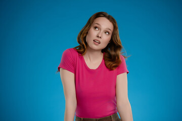 Woman posing in studio with expressive emotion against vibrant blue background while showcasing a...