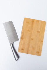 Top view of wooden cutting board, wooden spoons, knife and napkin on the white marble table.Empty space