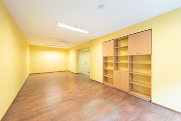 Minimalist Bright Office Room With Yellow Walls and Wooden Shelving Units