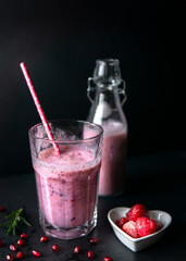 strawberry smoothie in a glass on black table