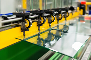 mirror manufacturing assembly line with freshly cut glass panels moving through automated machinery