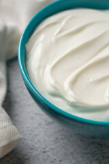 Top view of yogurt in bowl on grey stone table. Healthy eating concept