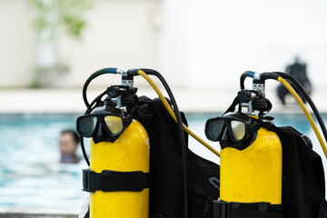 Scuba diving equipment on swimming pool.Diving mask and yellow oxygen tank for water rescue...