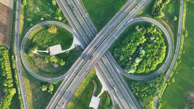 Aerial view of road junction with windmills and greenery near Bruges in Belgium during clear weather