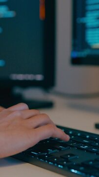 Vertical Screen : Closeup young adult Asia female freelance typing write prompt AI bot IT program nomad, video game, terminal with coding language, big data center on desktop computer in night office.