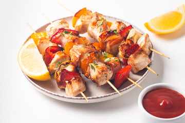 Delicious grilled chicken skewers with capsicum, lemon, salad and ketchup on a plate over the table. Chicken kebab. Healthy food concept.