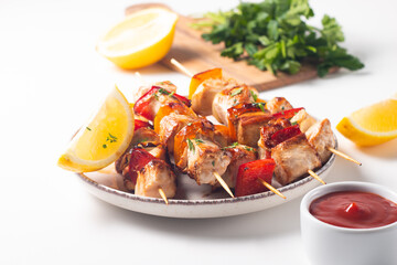 Delicious grilled chicken skewers with capsicum, lemon, salad and ketchup on a plate over the table. Chicken kebab. Healthy food concept.