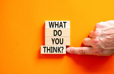 What do you think symbol. Concept words What do you think on beautiful wooden blocks. Beautiful orange table orange background. Businessman hand. Business and What do you think concept. Copy space.