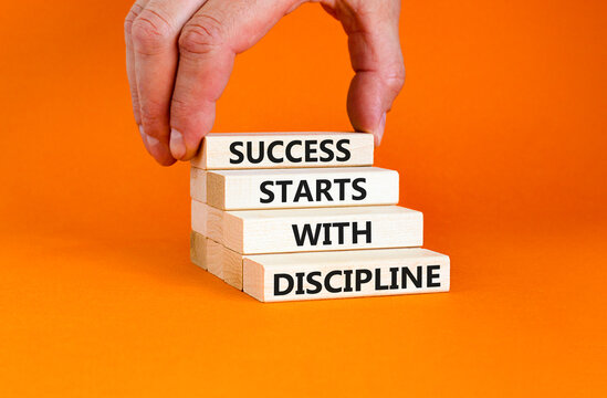 Success starts with discipline symbol. Concept words Success starts with discipline on beautiful wooden blocks. Beautiful orange background. Business success starts with discipline concept. Copy space