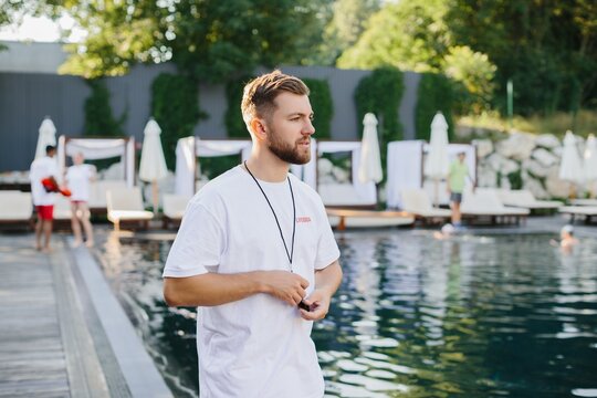 Lifeguard watching over bathers in swimming pool on sunny day