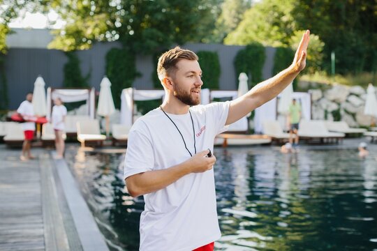Lifeguard gesturing and supervising swimming pool activities - Powered by Adobe