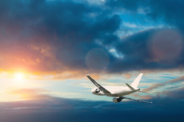 Airplane in the flight, dramatic sunset sky and flying airplane, travel by air concept, summer air...