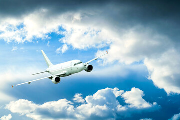 White passenger commercial airplane flying in the sky, travel background with airplane flying in...