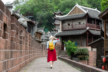Young female tourist looking at the beautiful landscape of Feng Huang Ancient Town, The famous...