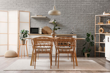 Interior of modern kitchen with dining table, counters and folding screen
