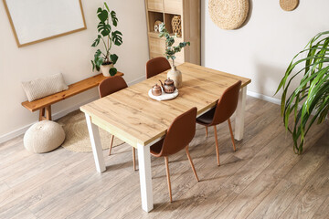 Interior of light room with dining table, shelf unit and bench