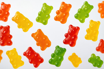 Colorful gummy bears scattered on a white background. Bright and appetizing candy evoking childhood memories and fun.