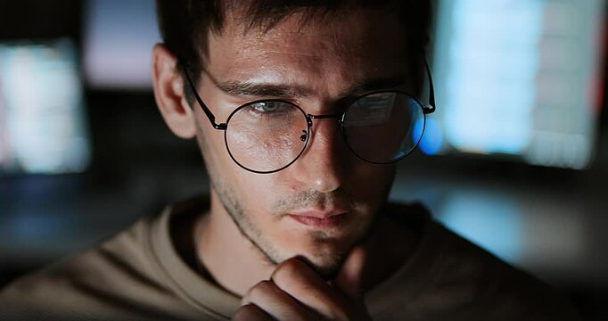 White Caucasian male software developer work late night, program coding in home office. Computer engineering job, data scientist, cybersecurity, information technology. Close-up eyeglasses, handheld