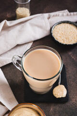 Coffee with sesame paste tahini in a cup on the table vertical view