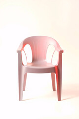 Fototapeta premium A modern pink plastic chair against a plain background.