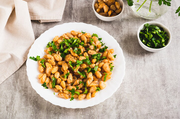 Homemade fried white beans and greens salad on plate on table