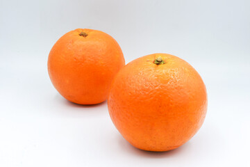 Three ripe oranges arranged on a neutral surface in soft studio light. This high-resolution food photograph emphasizes natural textures and round shapes, ideal for use in healthy eating articles
