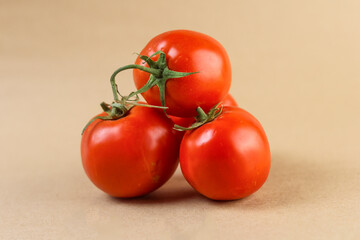 A studio photograph of three vine-ripened red tomatoes arranged in a triangular formation on a...