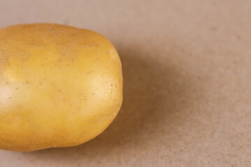 A high-definition studio photograph of a single yellow potato displayed in perfect side profile on...