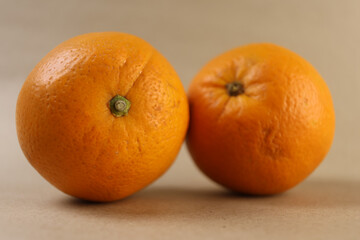 Close-up studio photograph of ripe oranges placed side by side. Captured in warm light, the image reveals surface texture and color gradients, ideal for healthy food campaigns and citrus product