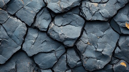 Fractured dark grey rock formation with rough edges, featuring fine cracks and crevices