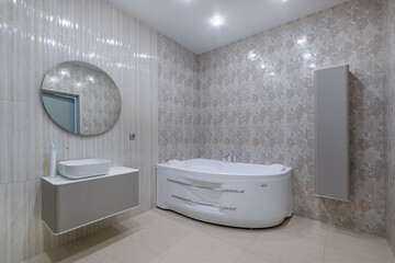 A hydro massage bath in the interior of an elegant bathroom. Different-textured tiles. Stylish...