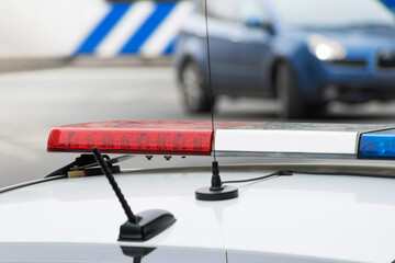 red and blue flashing light on police car and blue car turning towards it