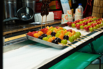 Colorful fruit skewers in street food style, vibrant colors, traditional Korean dessert display at Seoul, South Korea, Myeongdong Market