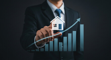 Businessman touching house icon on graph with rising arrow showing real estate market growth concept