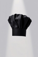 A black chef hat against a plain background.