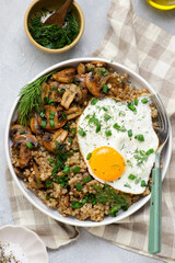 Bowl with buckwheat, fried mushrooms and fried egg for breakfast. vegeterian dish