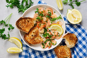 Lemon garlic butter shrimp in a white frying pan.top view