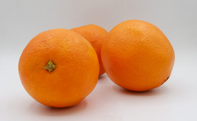 Clean arrangement of three oranges aligned on a seamless studio background. The even spacing, vibrant hues, and smooth textures offer a fresh visual perfect for fruit-focused ads, citrus juice packagi