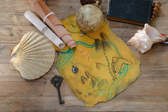 Pirate treasure map with compass, shells, and feather quill, evoking adventure, Vintage exploration setup, creative party planning for family fun, adventurous family quest