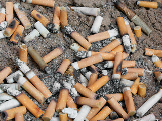 cigarettes stubbed out in bucket of sand outside pub
