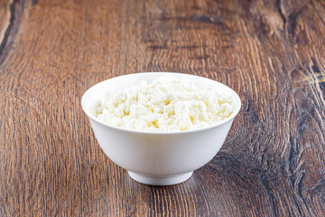 White bowl with fresh tasty cottage cheese.