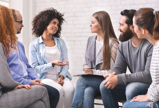 Progress of rehabilitation. Cheerful african woman sharing her achievements at group therapy, free space