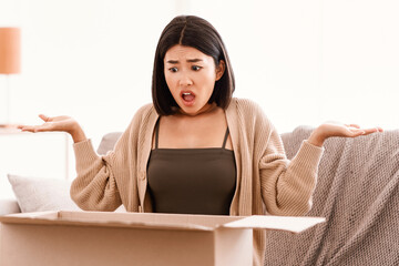 Wrong Or Damaged Package. Angry frustrated asian lady unboxing her delivery, shocked by shipping...