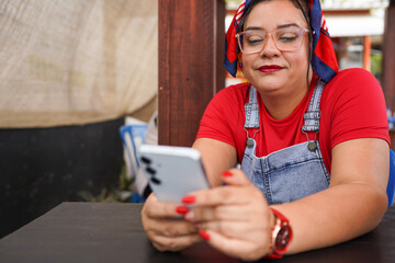 Latina entrepreneur managing her small business using smartphone