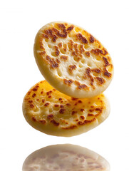 Fluffy golden crumpets, toasted and fresh for breakfast or a light snack, isolated on white background.
